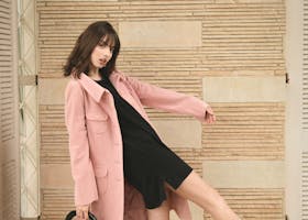 pexels-photo-2043590-2043590 Fashion model in pink coat and black dress striking a dynamic pose indoors with stylish black heels.